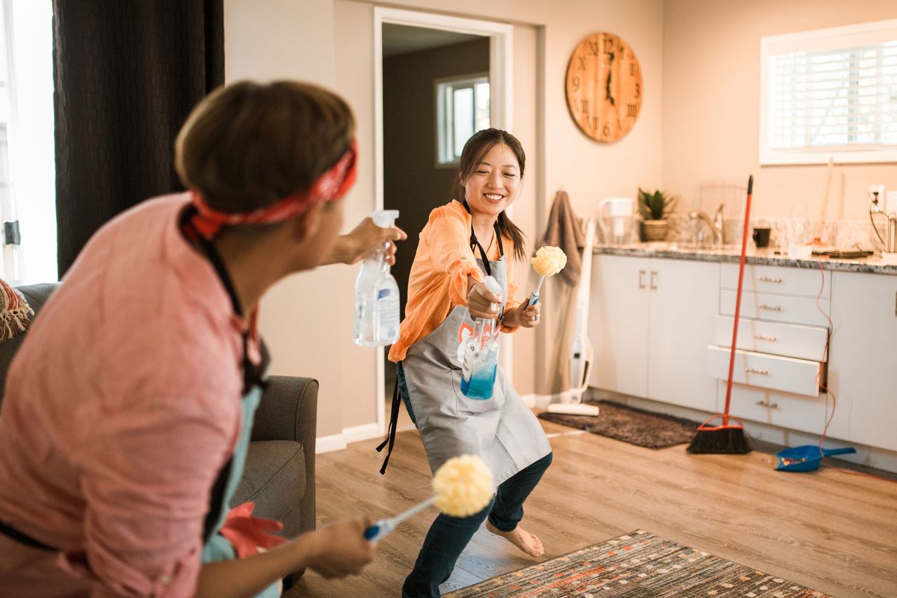 services-01 Asian couple having fun while cleaning their home, enhancing a cheerful atmosphere.