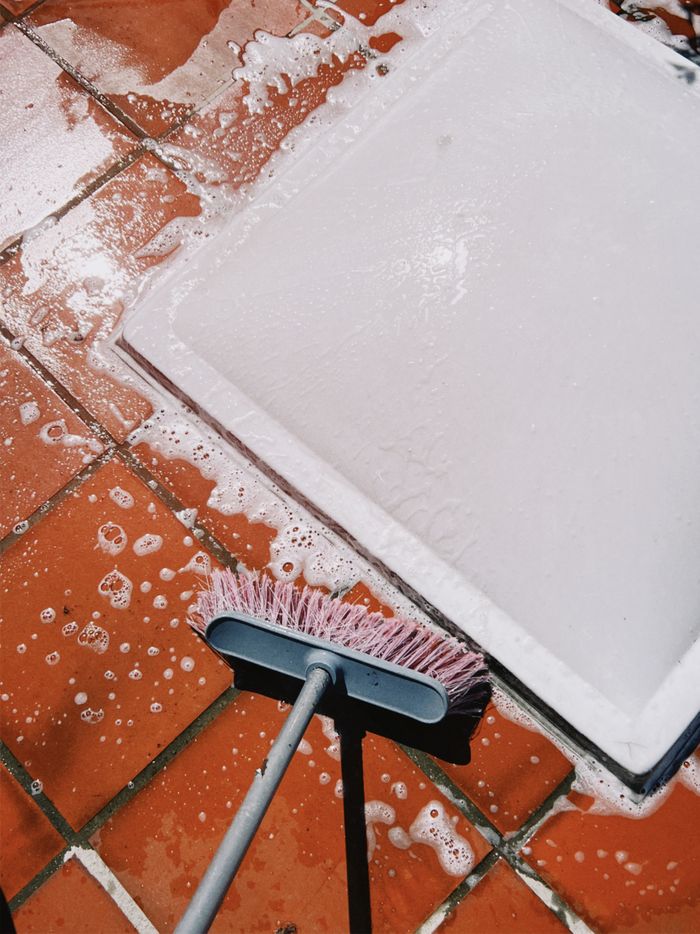 hero-02 Close-up of soapy tiles being scrubbed. Perfect for cleaning and maintenance themes.
